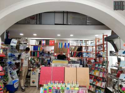 L�ambiente � diviso da una volta ad arco in pietra bianca. Ad aggiungere per� colore ci pensano i variopinti articoli di cancelleria: bloc-notes di varie dimensioni, agende, quaderni e raccoglitori sistemati dietro al bancone